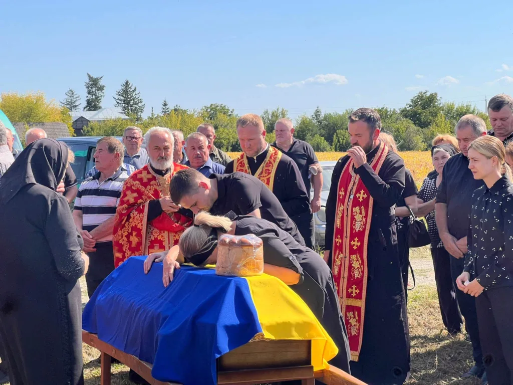 Прощання з військовим біля труни, вкритої прапором України
