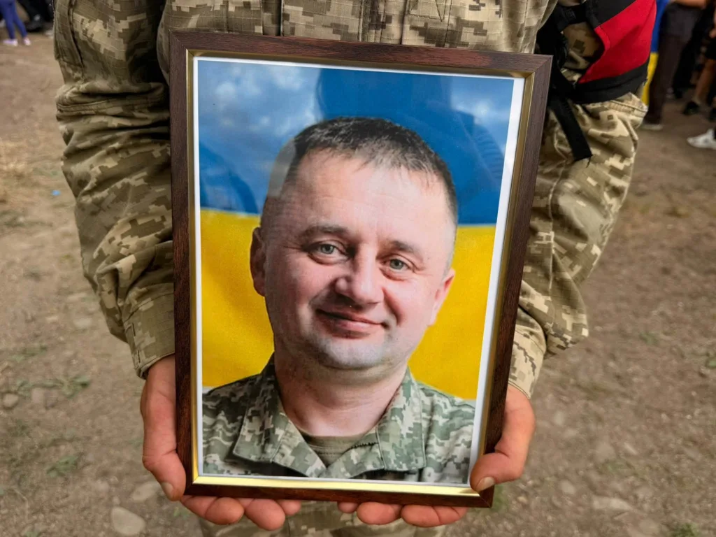 Військовий тримає портрет загиблого побратима