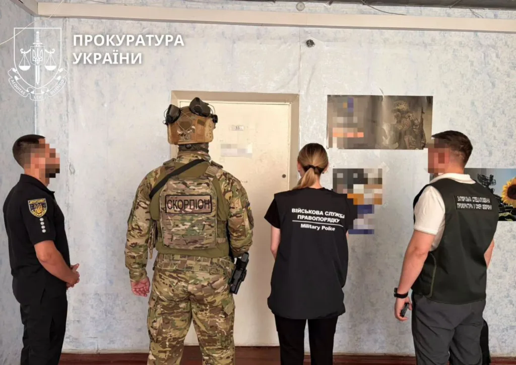 Правоохоронці біля дверей квартири під час слідчих дій