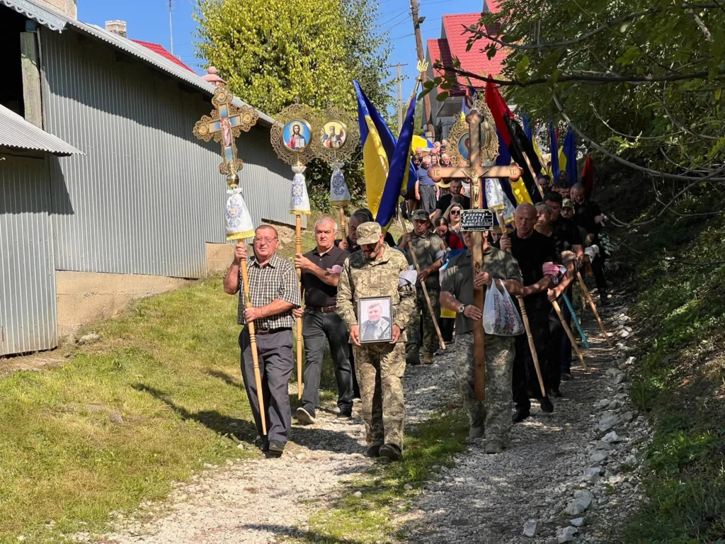 Жалобна хода з портретом військового, прапорами та церковними хоругвами