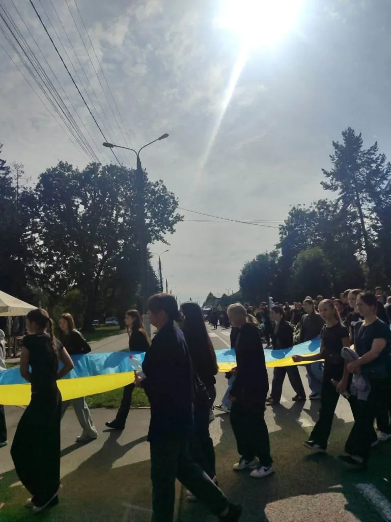 Люди несуть великий український прапор вулицею