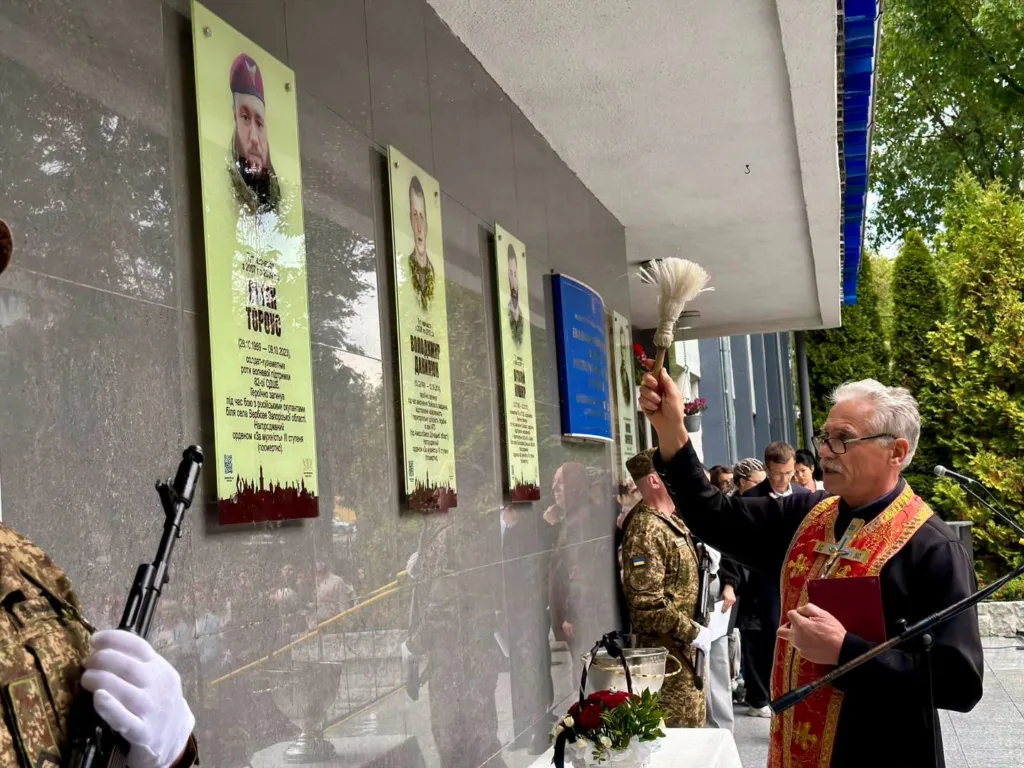Священник освячує меморіальні дошки загиблим військовим