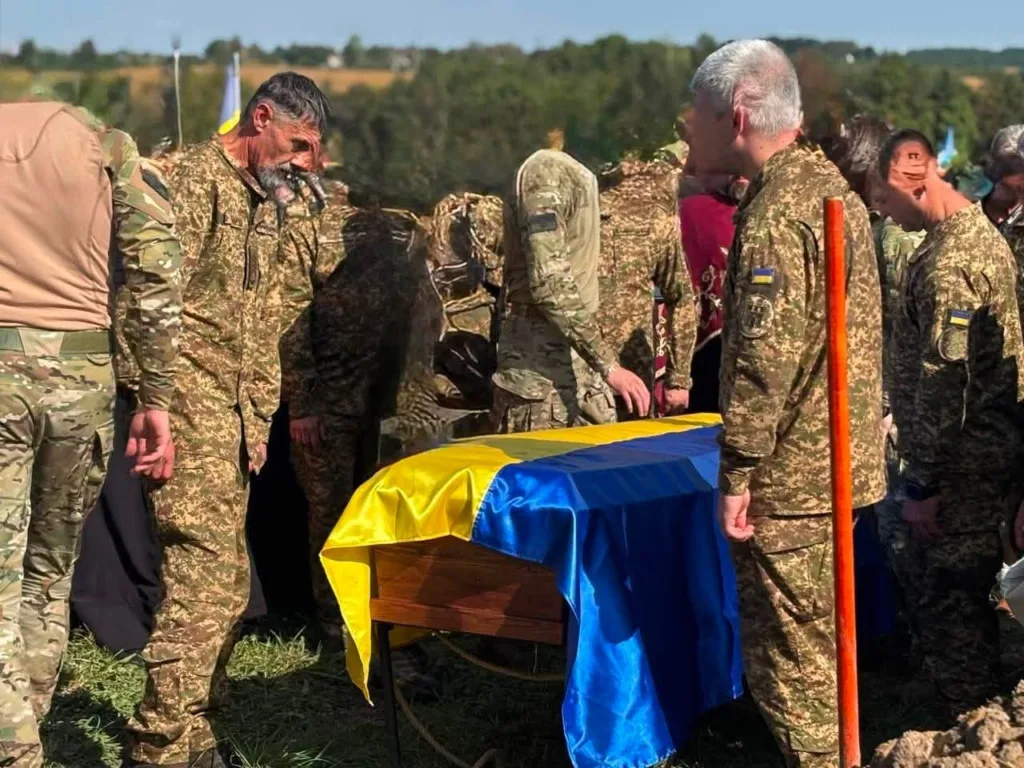 Військові прощаються з полеглим біля труни під прапором України