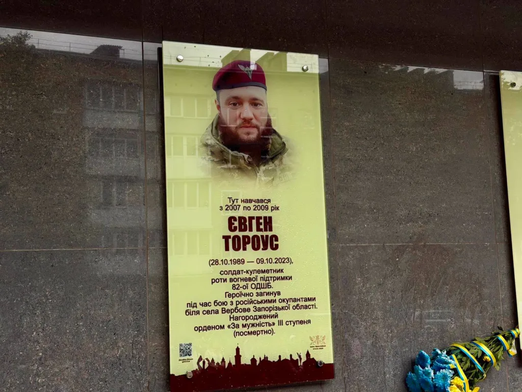 Меморіальна дошка загиблому воїну Євгену Торусу з квітами