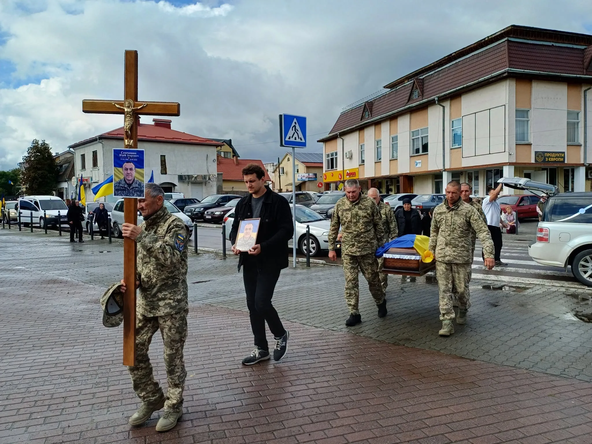 Військові несуть труну героя під українським прапором