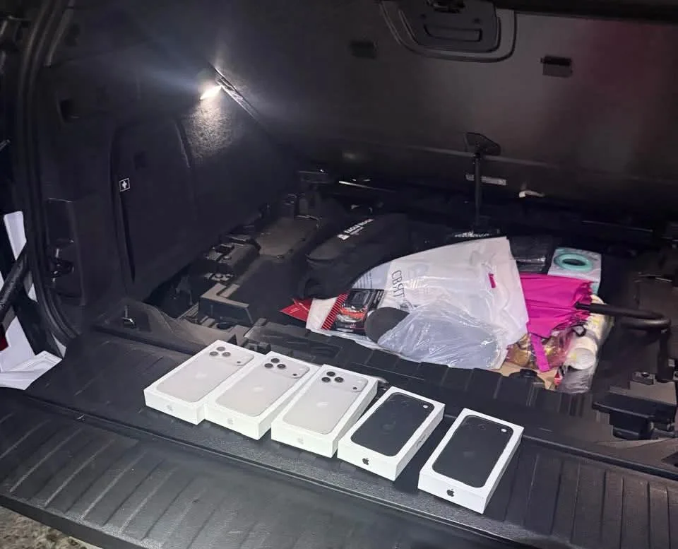П’ять коробок iPhone у відкритому багажнику автомобіля