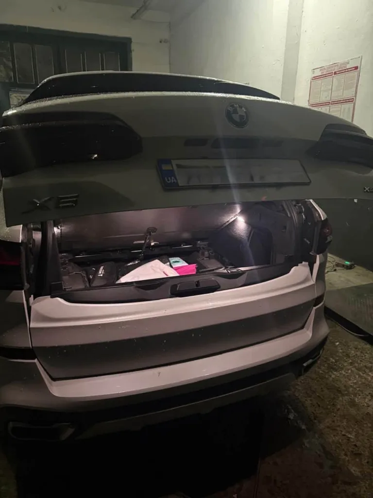 Відкритий багажник білого BMW X6 у гаражі