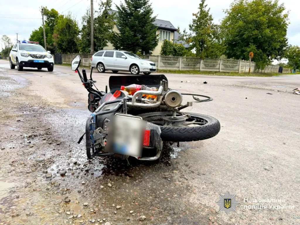 Перекинутий мотоцикл після ДТП, поруч поліцейський автомобіль