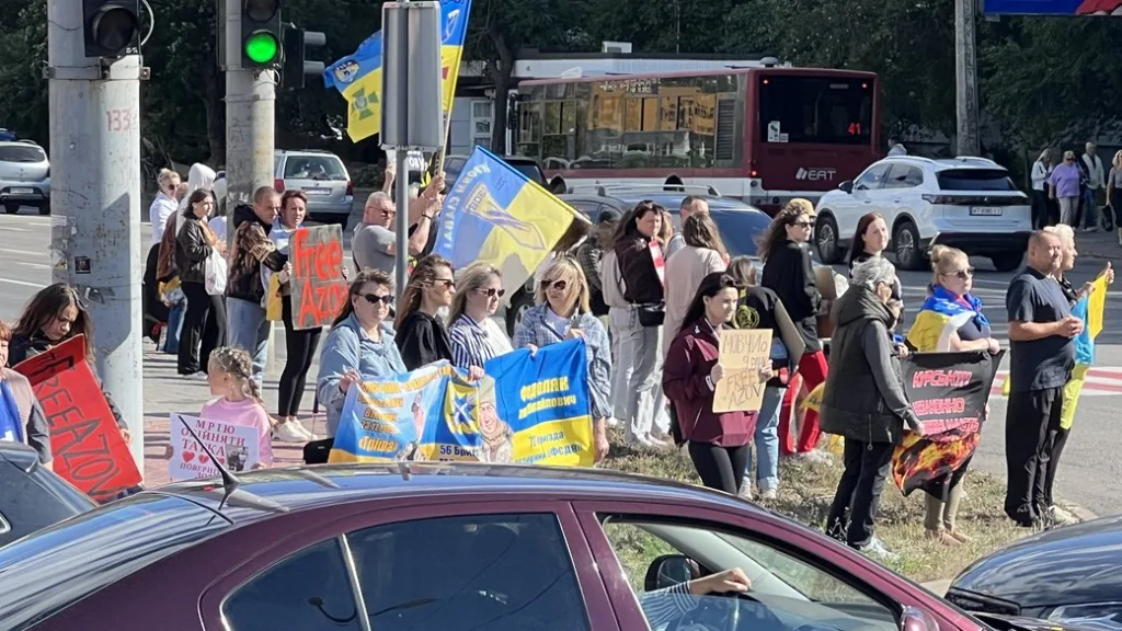 Учасники мітингу з українськими прапорами та плакатами «Free Azov»