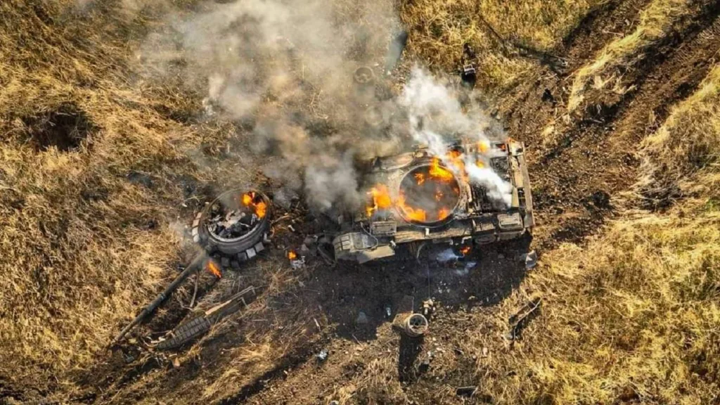 Знищений танк горить у полі, видно дим