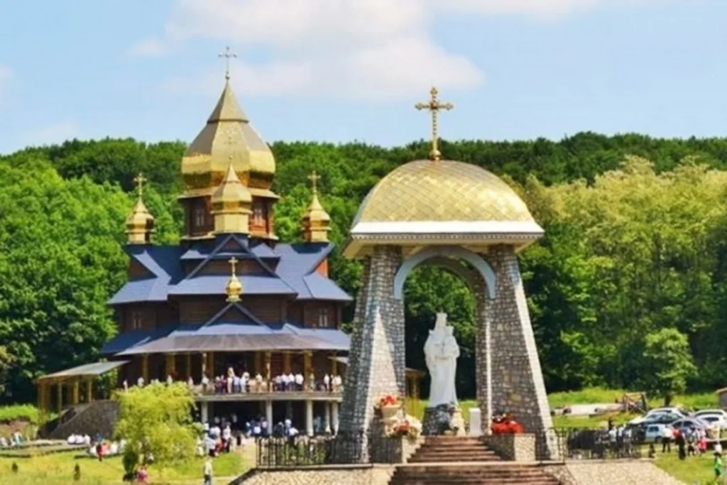 Дерев’яна церква з золотими банями та аркою