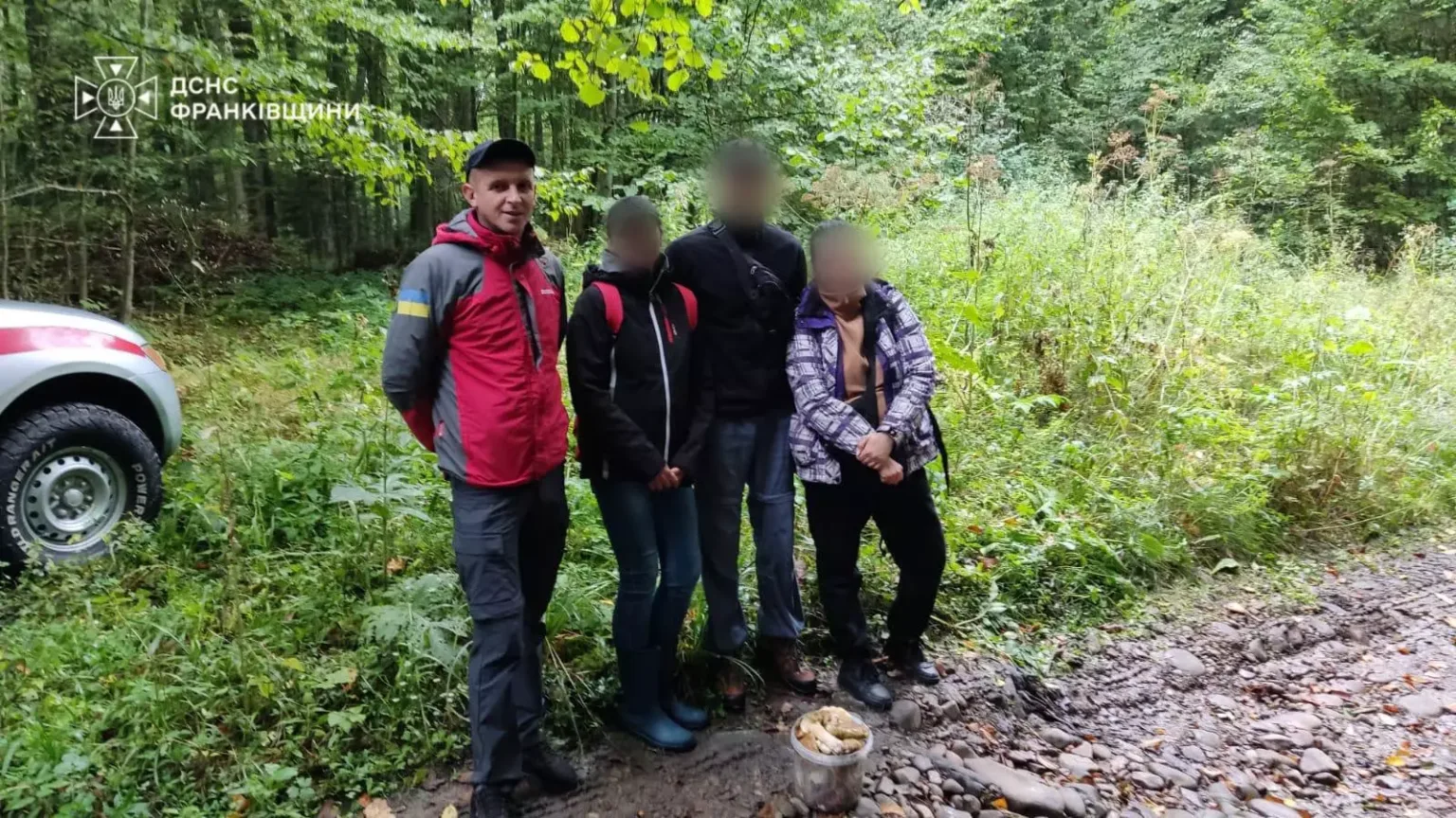 Рятувальник із трьома людьми на лісовій дорозі