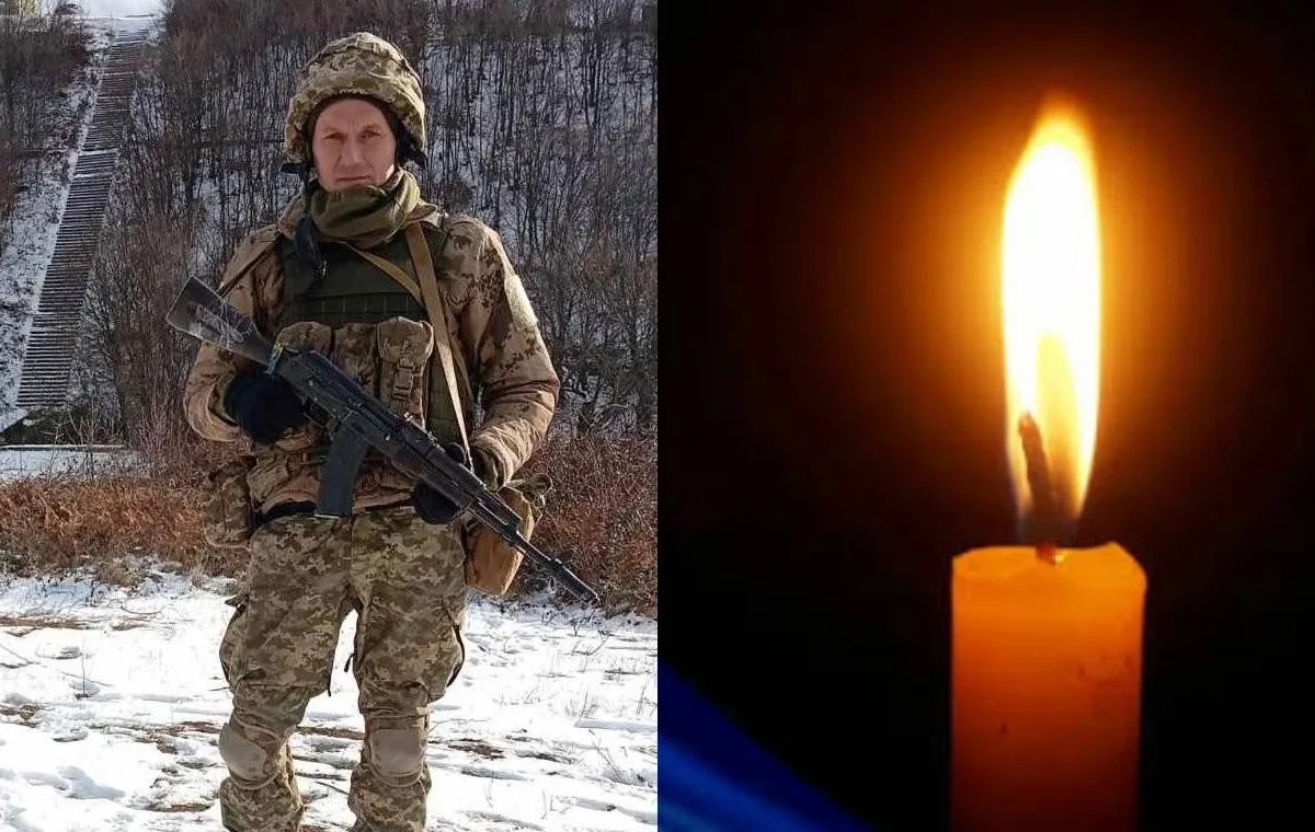 Військовий зі зброєю поруч із запаленою свічкою