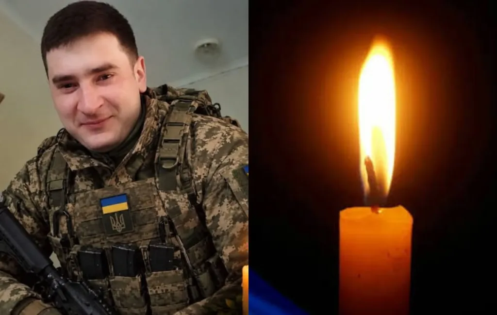 Український військовий поруч із запаленою поминальною свічкою