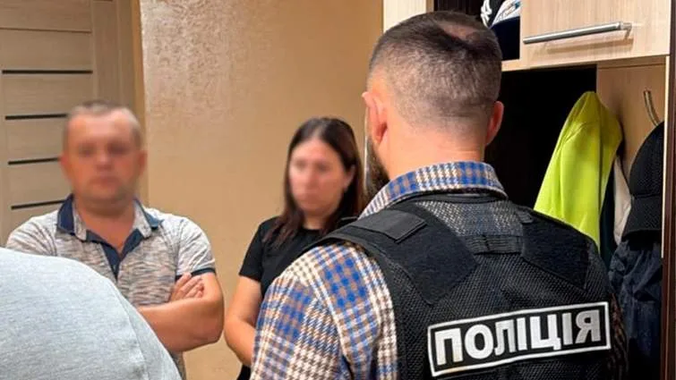 Поліцейський спілкується з двома людьми у коридорі