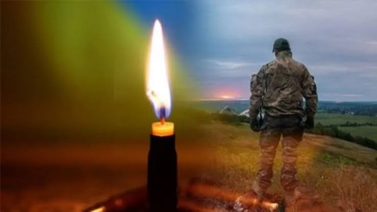 Палаюча свічка і військовий на тлі заходу сонця