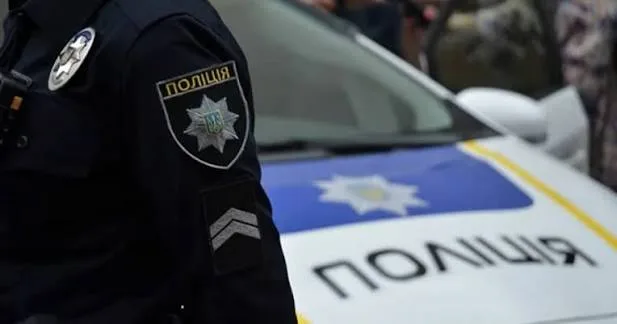 Український поліцейський біля патрульного автомобіля