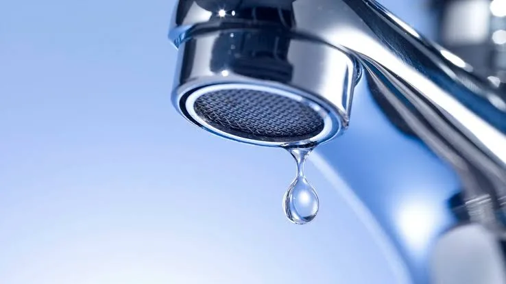 Крапля води звисає з блискучого крана