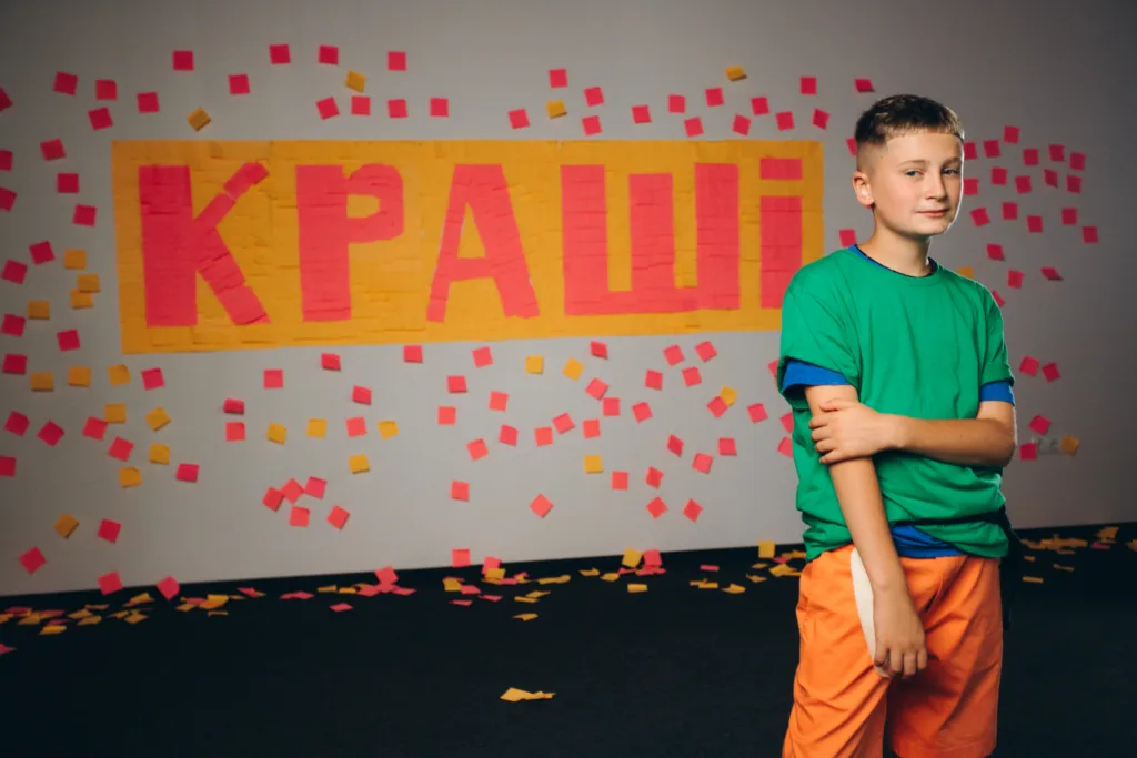 Хлопець за склом із рожевими та жовтими стікерами