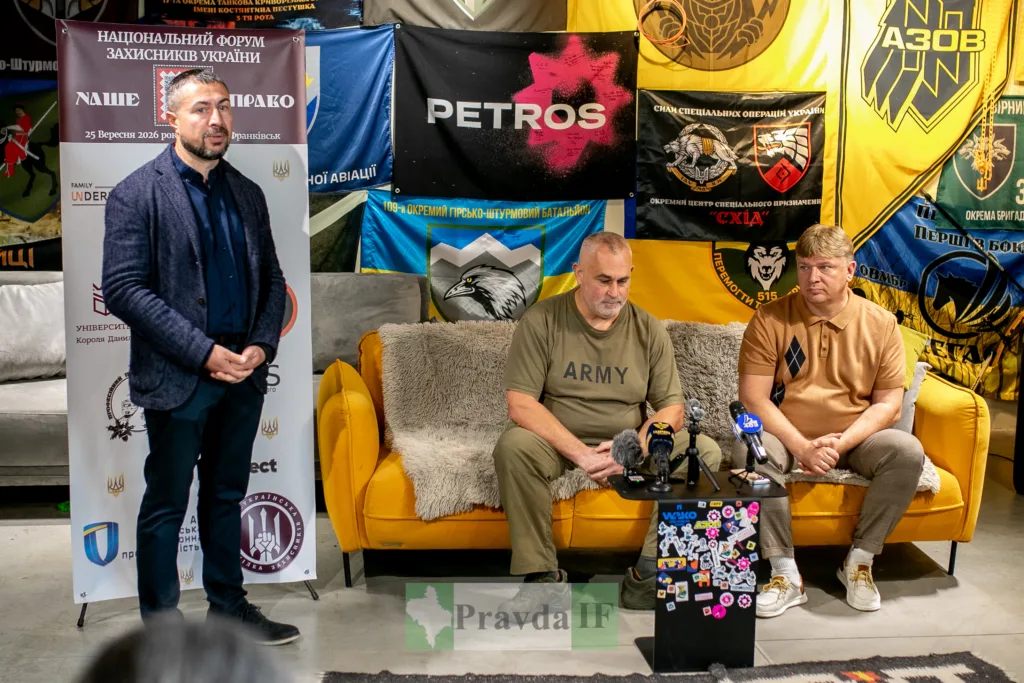 Учасники форуму захисників України на тлі військових прапорів