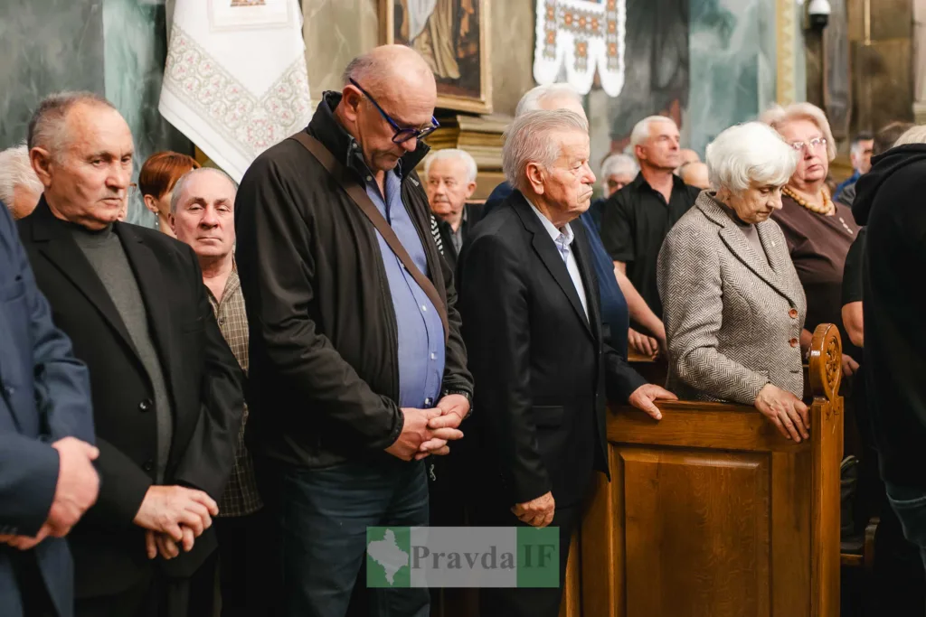 Люди стоять у молитві в переповненій церкві