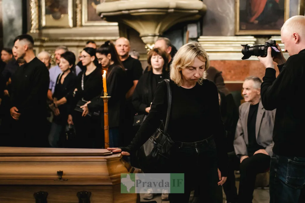 Люди прощаються біля труни в церкві