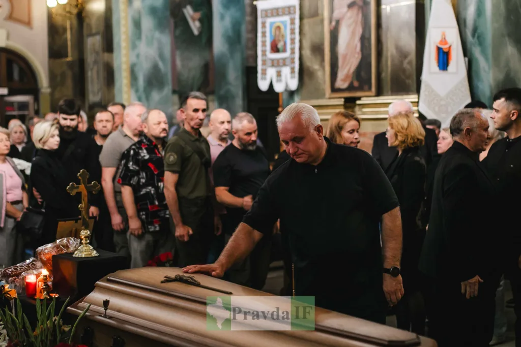 Люди прощаються з померлим у храмі біля труни