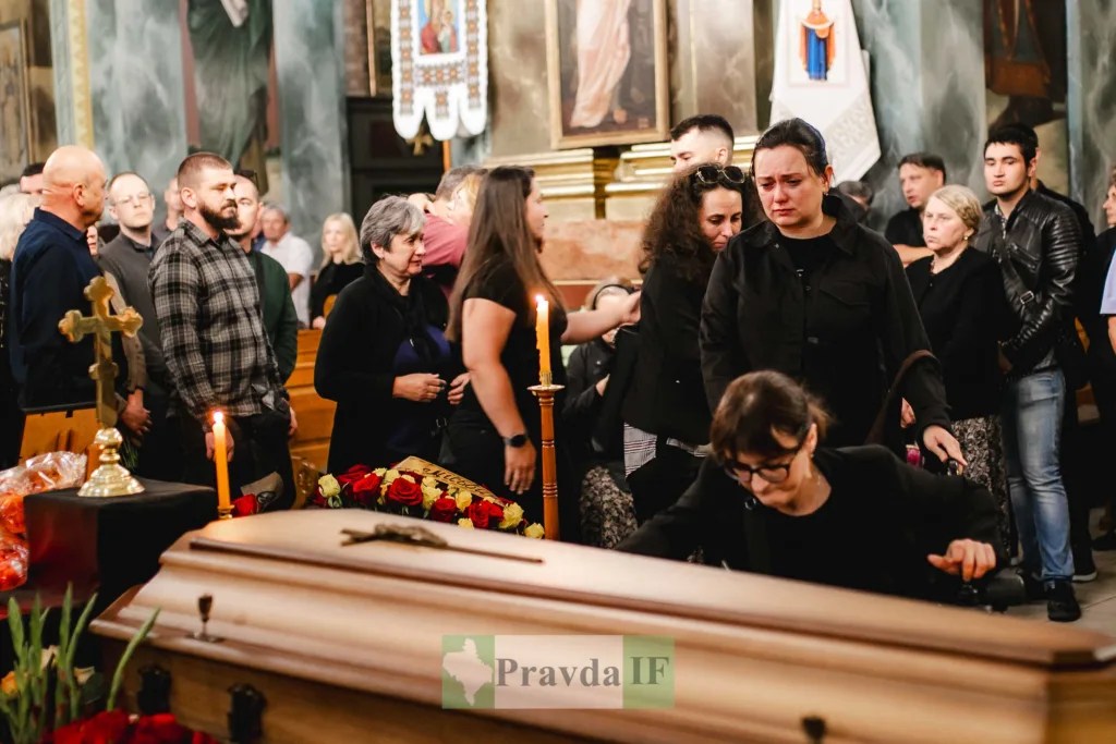Люди прощаються з померлим у храмі біля труни