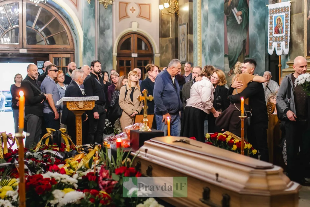 Люди прощаються з померлим у церкві біля труни