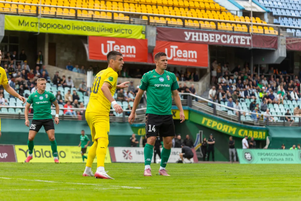 Футболісти в жовтій і зеленій формах на полі