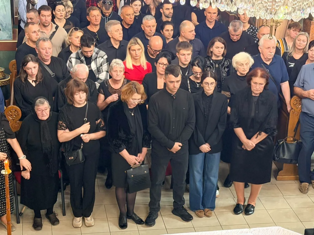 Люди в чорному мовчки зібралися в приміщенні