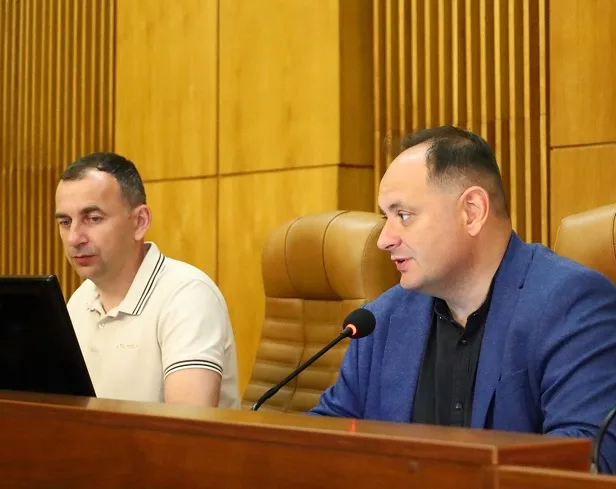 Двоє чоловіків виступають на засіданні за трибуною