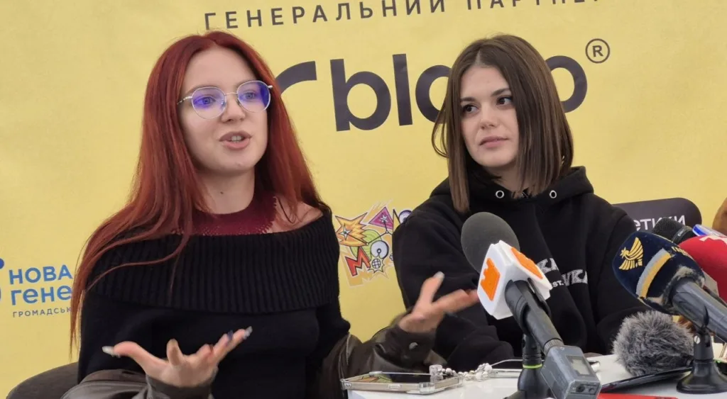 Дві жінки виступають перед мікрофонами на пресконференції