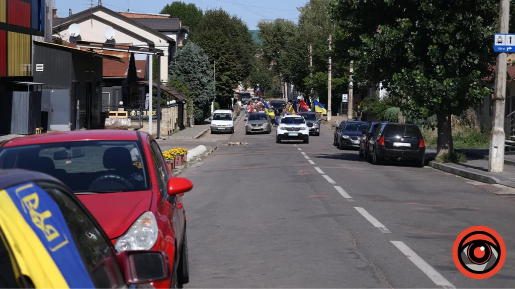 Автоколона з українськими прапорами на міській вулиці