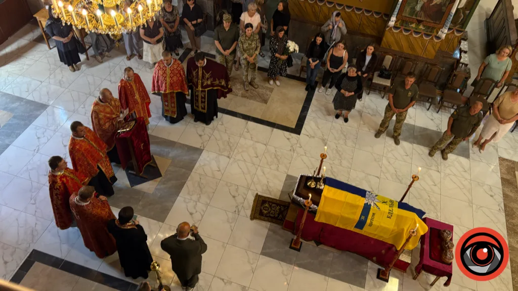 Похоронна служба в церкві біля труни з українським прапором