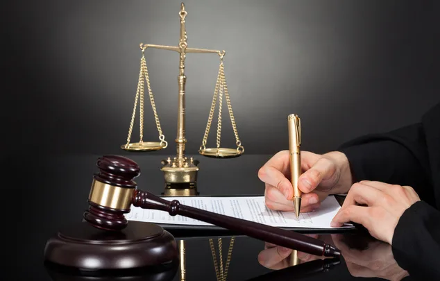 Суддівський молоток, терези правосуддя та підписання документа