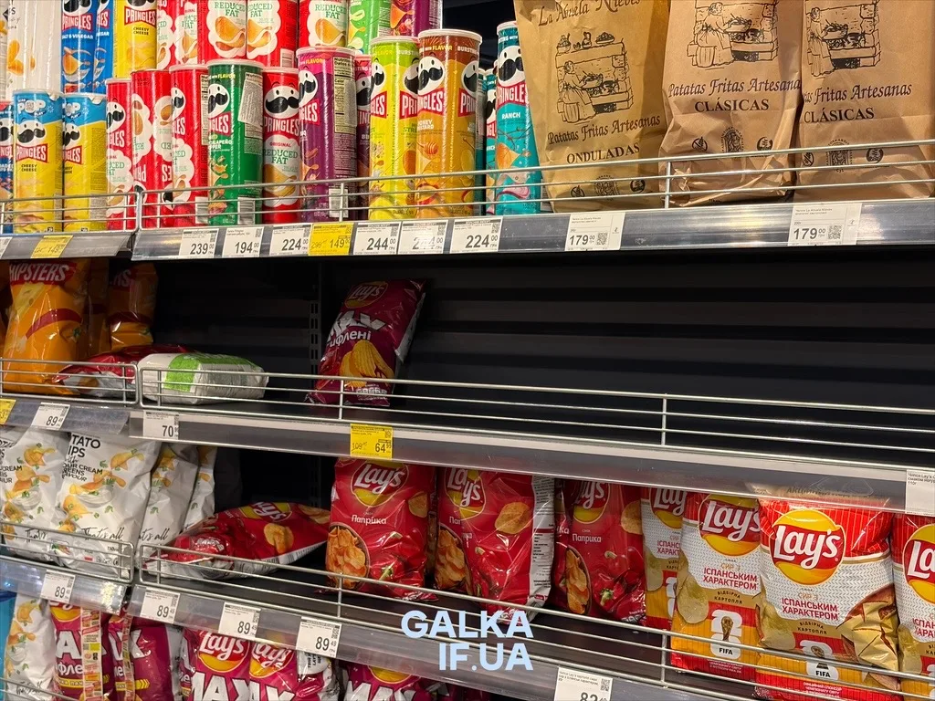 Полиці супермаркету з Pringles, Lay’s та іншими чипсами