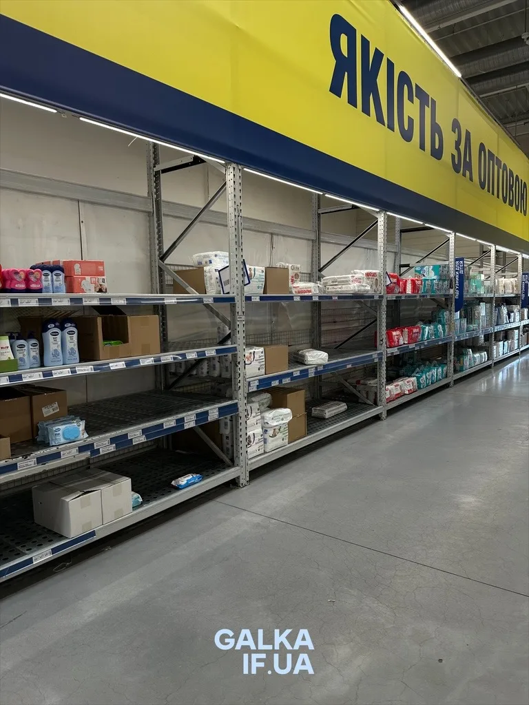 Майже порожні полиці магазину з написом «Якість за оптовою»