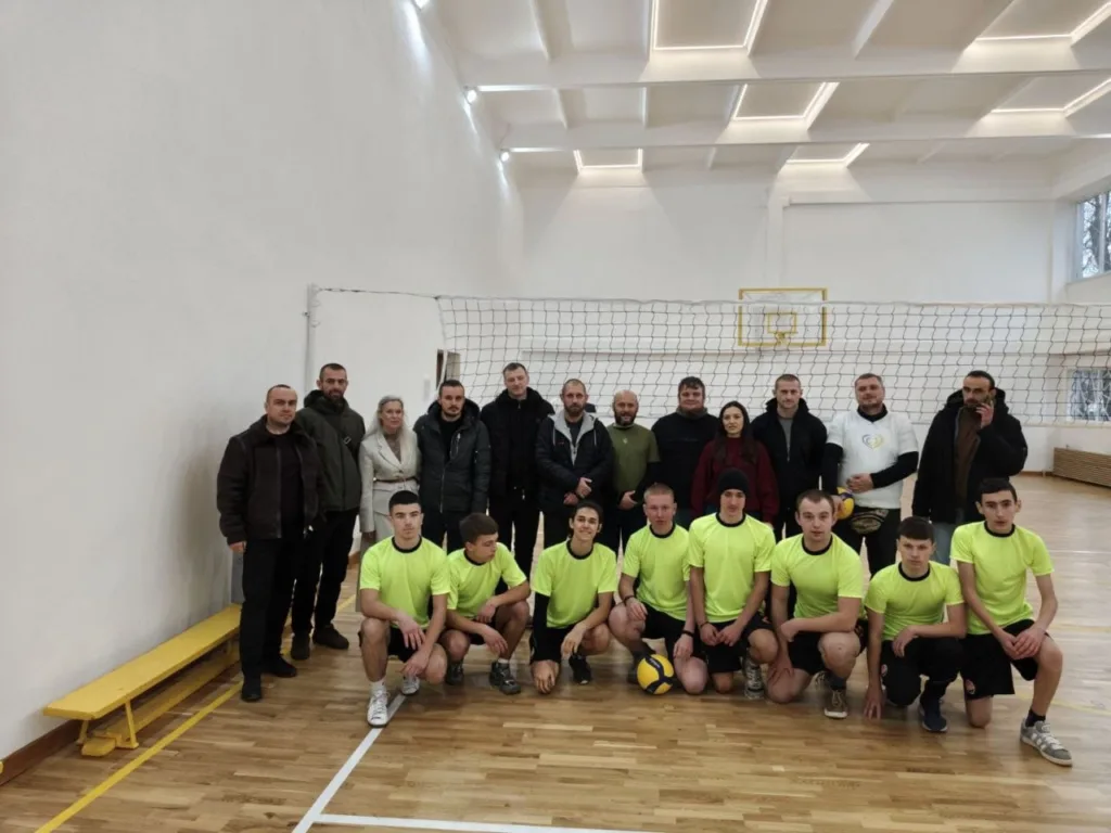 Волейбольна команда та вболівальники у спортивній залі