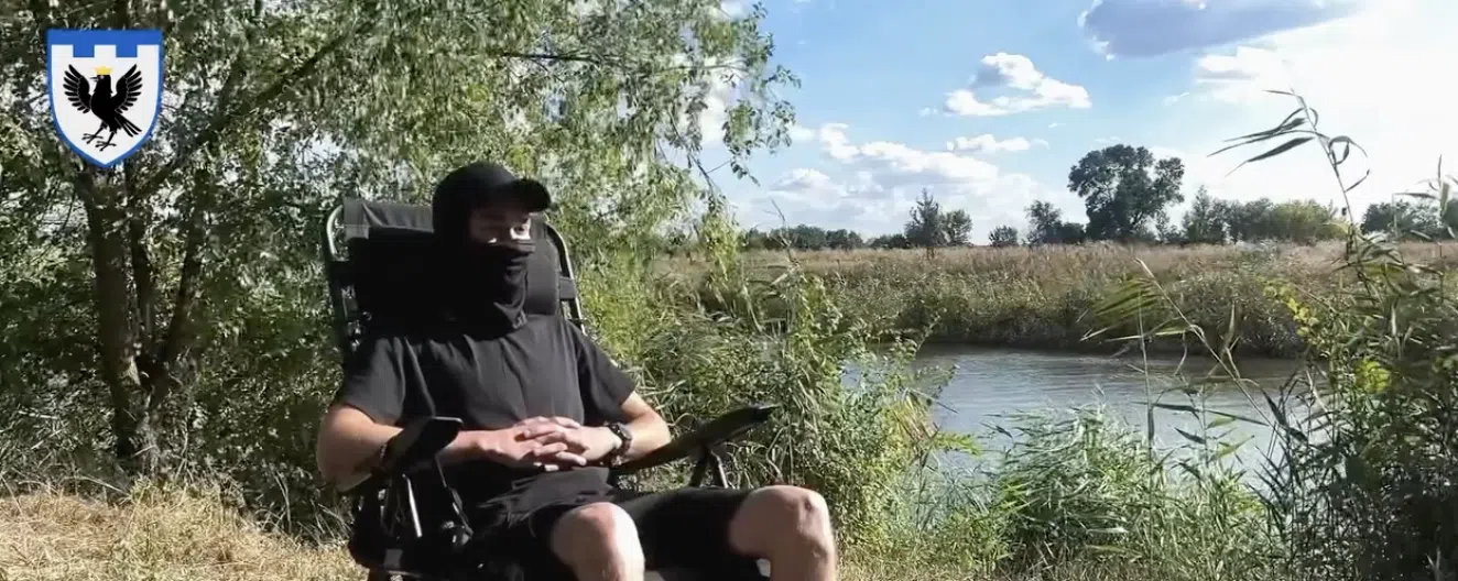 Замаскований чоловік у кріслі колісному біля річки